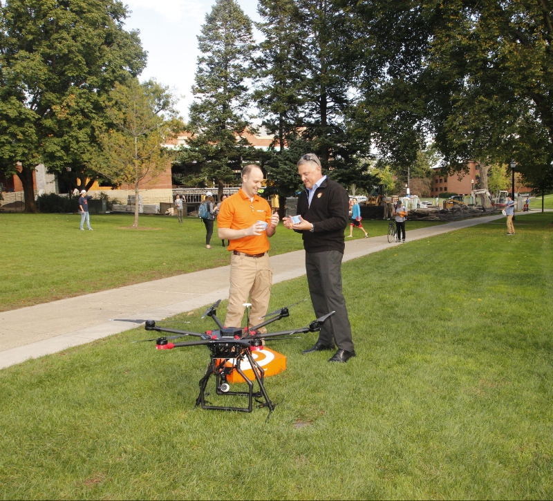 Orange Leaf President, Geoff Goodman, and franchise store owner, Jeremy Latchaw, celebrate the landing of the brand&apos;s delivery of frozen yogurt by drone. (PRNewsFoto/Orange Leaf Frozen Yogurt)